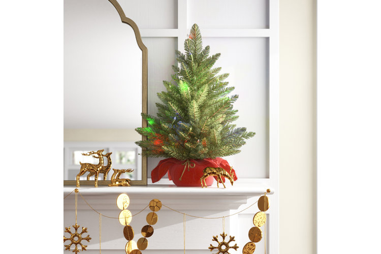 miniature lighted christmas tree on a mantle