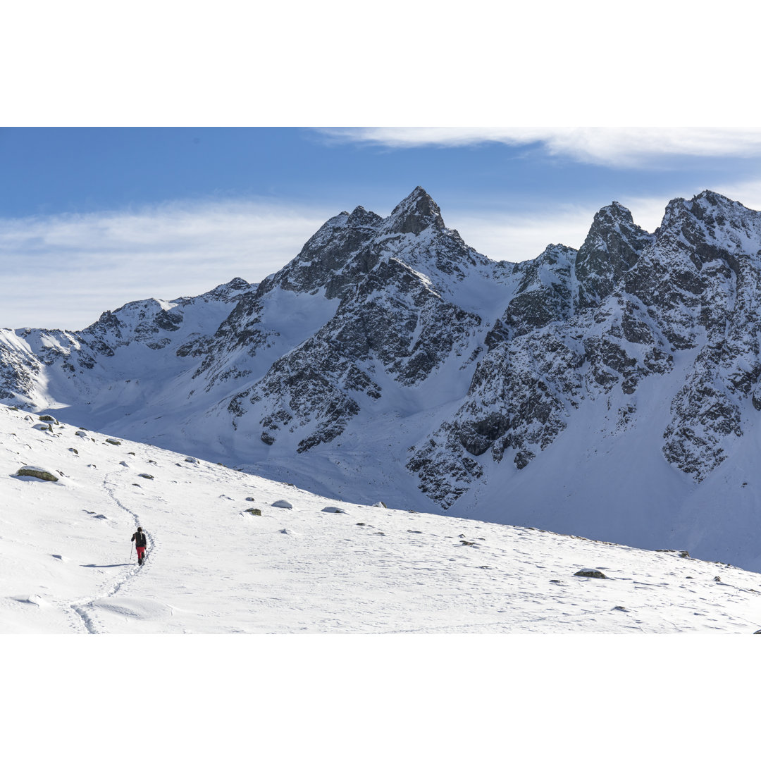 Wanderer wandert auf verschneitem Berg - Leinwandbild