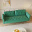 Un canapé-lit de 69,7 pouces de long recouvert de velours vert, doté d'une garniture cloutée et d'un coussin décoratif assorti