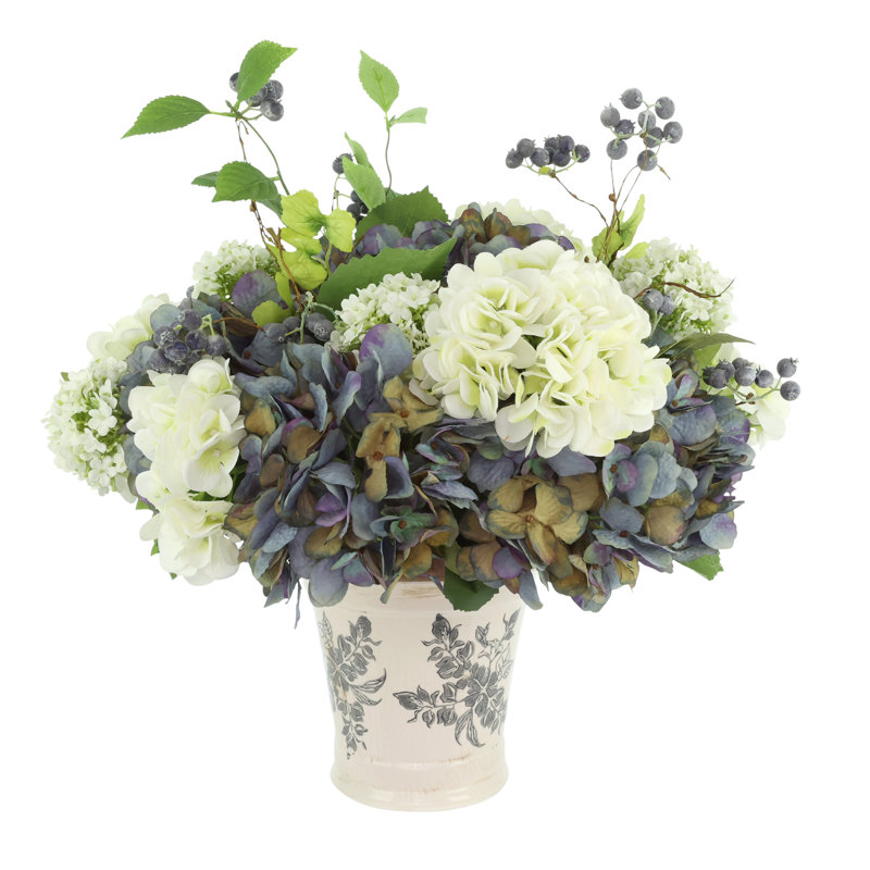 Hortensia et viburnum disposés dans un vase en céramique avec baies