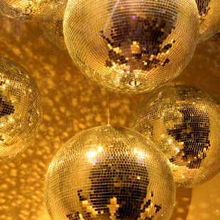 Golden disco mirror ball reflect light on glitter canvas