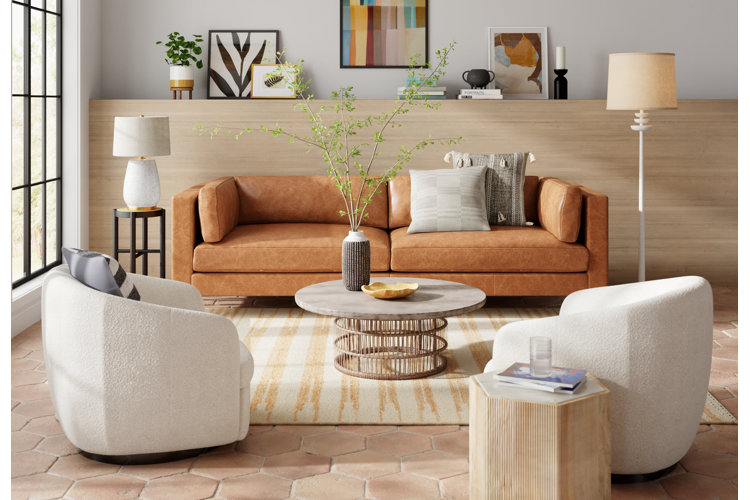 modern living room with a leather sofa and two wool barrel chairs around a drum coffee table