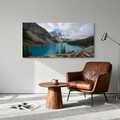 Tableau sur toile représentant un lac de montagne turquoise avec des sommets enneigés et des pins
