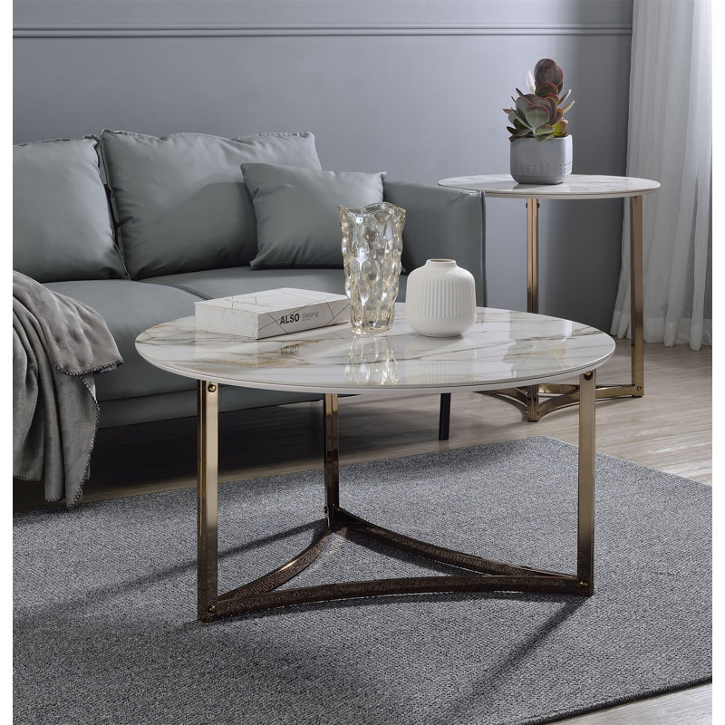 Table basse ronde avec plateau en pierre frittée et structure en métal champagne