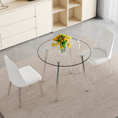 Ensemble de table et de chaises de salle à manger de luxe moderne en verre de 36 pouces de diamètre avec pieds en métal argenté et deux chaises blanches avec coussins en polyuréthane et pieds en métal argenté.