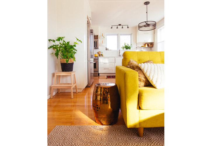 A yellow sofa with a gold garden stool