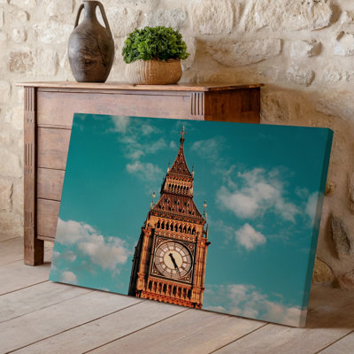 Toile, une grande tour de l'horloge emblématique contre un ciel turquoise serein ornée de nuages blancs moelleux