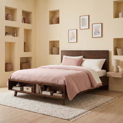 Lit plateforme en bois avec espace de rangement au pied du lit et tête de lit à panneaux