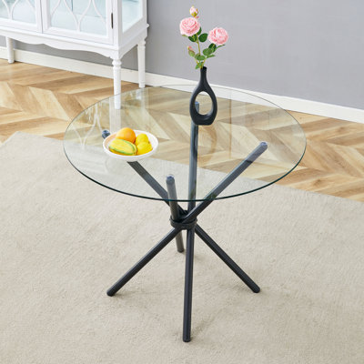 Une table ronde circulaire en verre trempé transparent d'un diamètre de 36,6 po, avec des pieds en métal noir rassemblés en forme d'anneau. Le verre du bureau a une épaisseur de 0,3 po