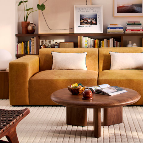 A cozy living room featuring a mustard yellow sofa and a wooden coffee table