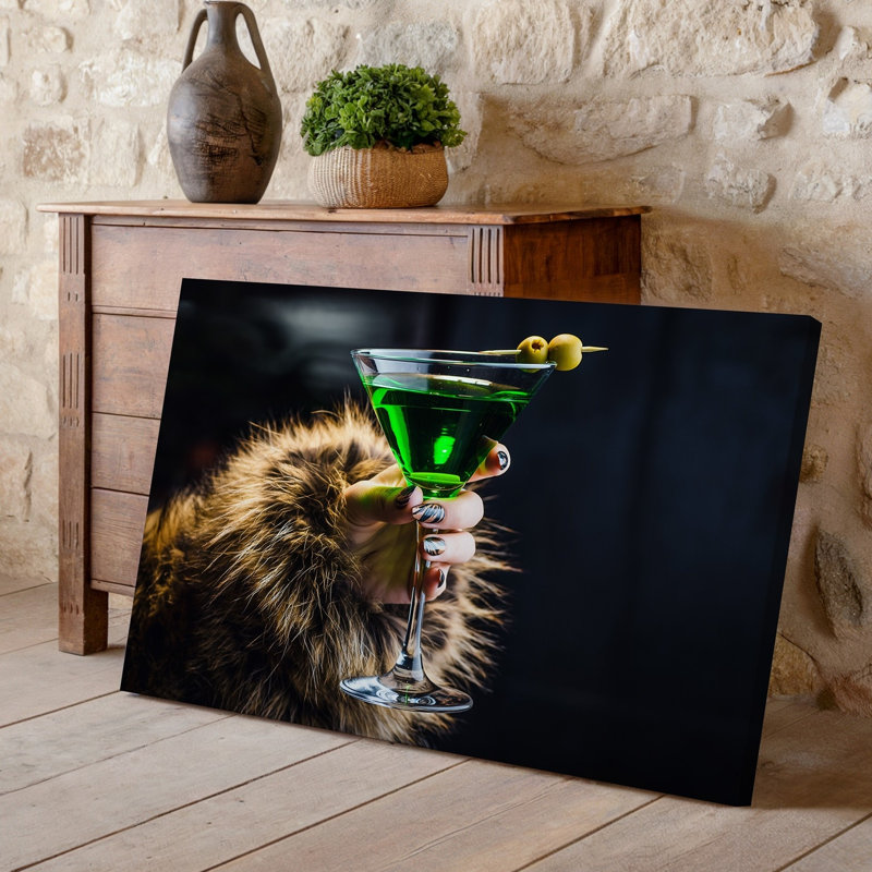 Toile, gros plan sur une main élégamment manucurée tenant un verre à martini en cristal rempli d'un cocktail vert éclatant