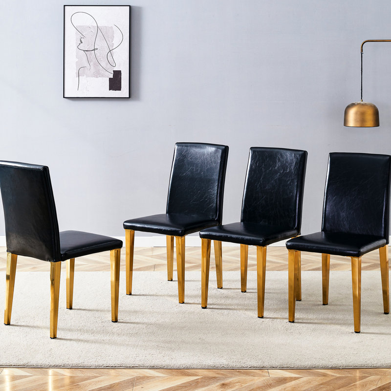 4 chaises de salle à manger en polyuréthane noir avec des pieds en métal doré et des pieds au design confortable et élégant