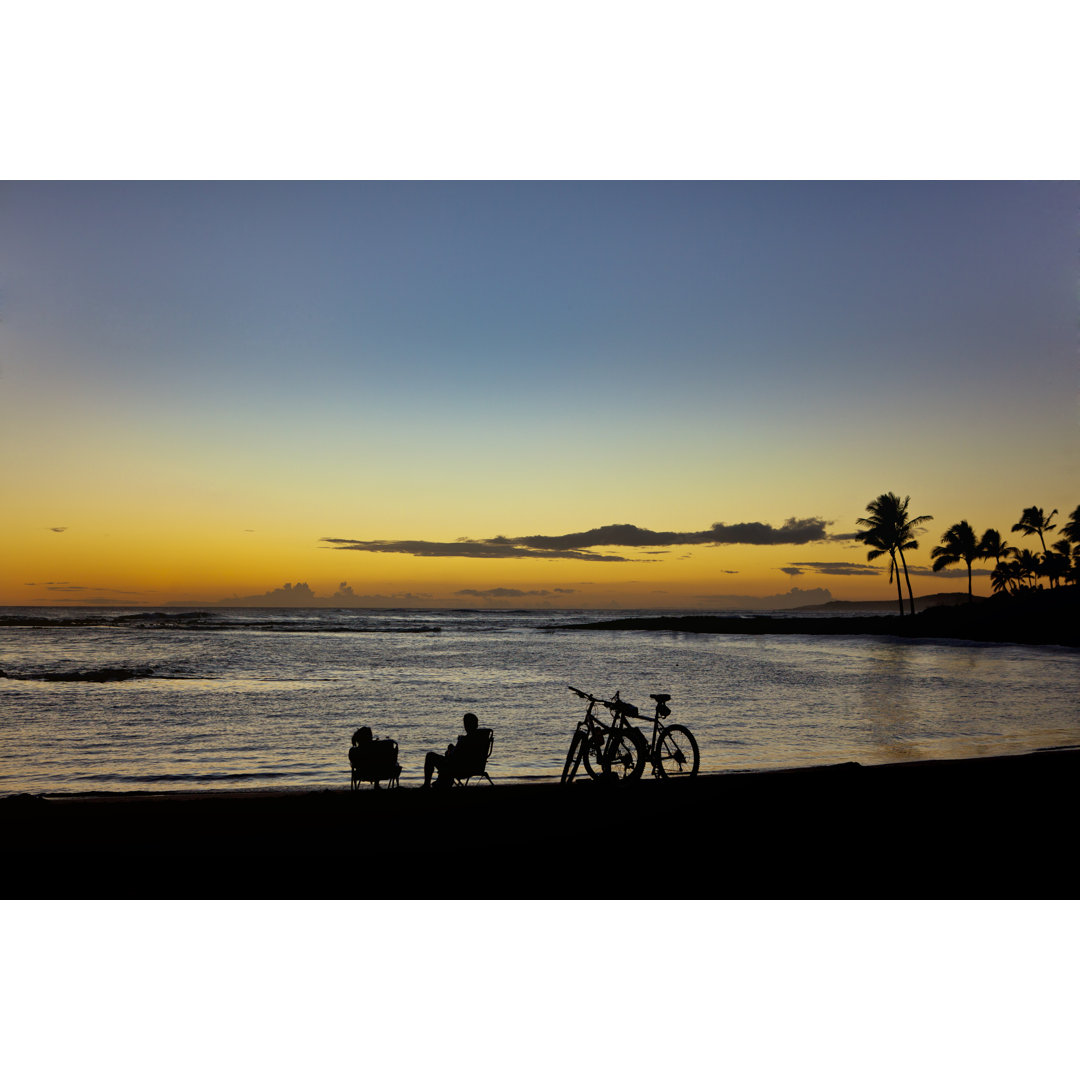 Touristen bei Sonnenuntergang am Strand von Hawaii