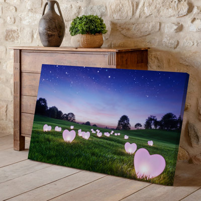 Canvas A Serene Twilight Scene In A Lush Green Field Dotted Wall Art With Glowing Pink Heart Shaped Lights That Illuminate The Grass Canvas Wall Art