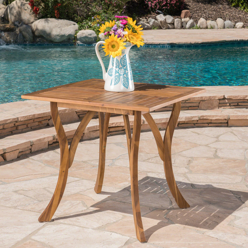 La table carrée en bois de 31,5 po ajoute une touche côtière à l'extérieur du patio