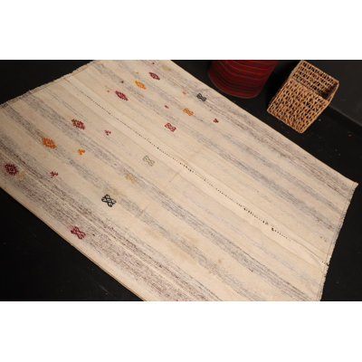 Tapis turc beige fabriqué à la main avec des motifs géométriques vibrants fabriqués à partir de laine authentique pour une véritable touche d'élégance artisanale