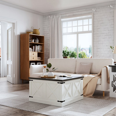 Table basse blanche avec des accents en métal noir vieilli et un rangement caché pour les couvertures de salon et les compartiments de quincaillerie industrielle