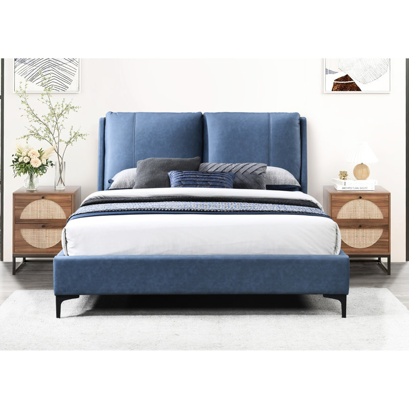 Grand lit plateforme tapissier bleu avec une tête de lit généreuse et un oreiller spacieux