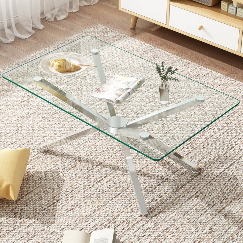 Table basse moderne en verre trempé avec pieds argentés et salon élégant