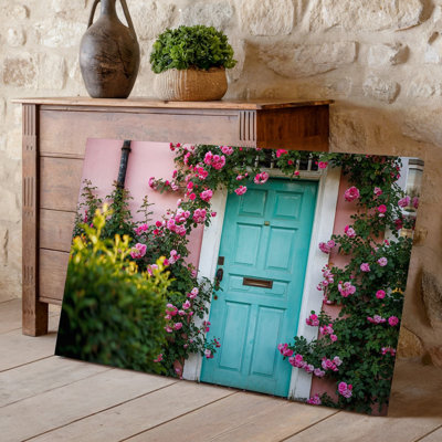Toile, une porte turquoise vieillie se dresse en évidence contre un rose tendre, art mural orné de roses vibrantes