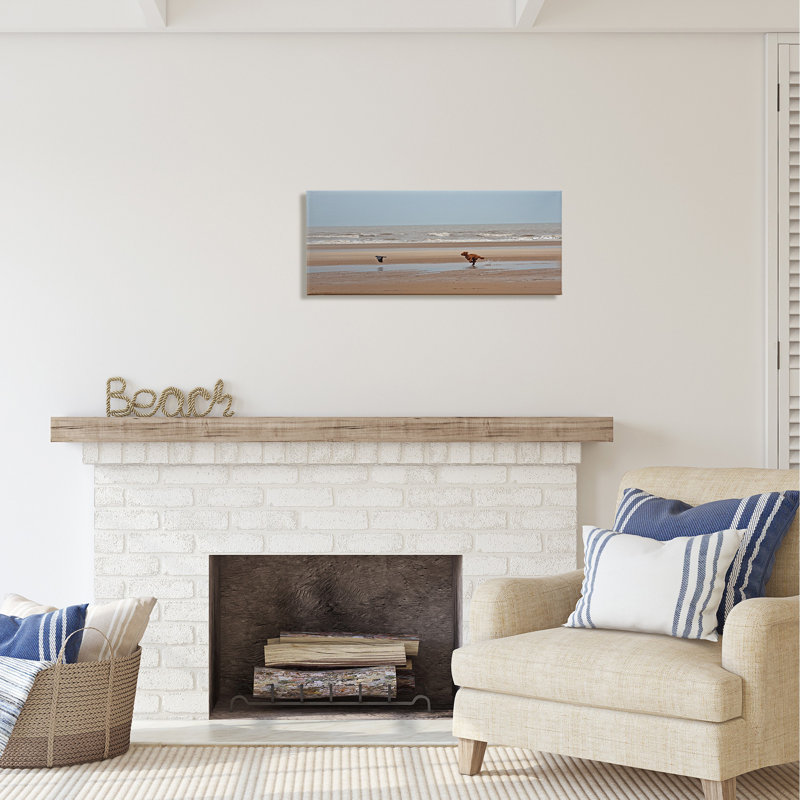 «Dog Chassing Bird on Beach» par Gill Woodcock - reproduction d'art sur toile tendue, H 13 po x l 30 po x P 1,5 po
