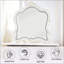 Miroir exquis avec bord biseauté, bordure ornementale à volutes et couronne