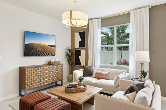 Living room with white sofas, wood furniture, and desert artwork.