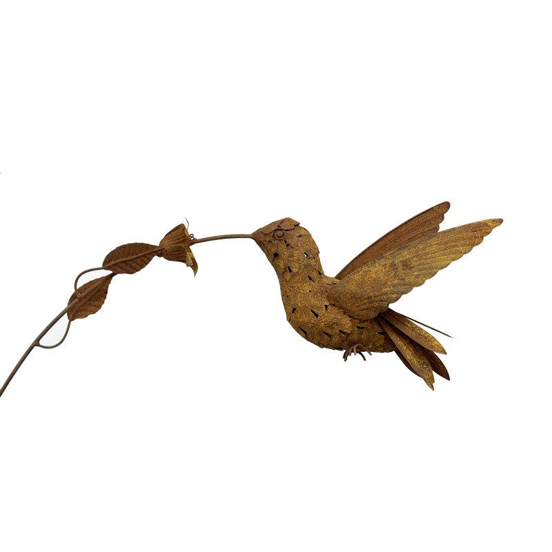 Colibri rustique sur piquet de jardin fleuri