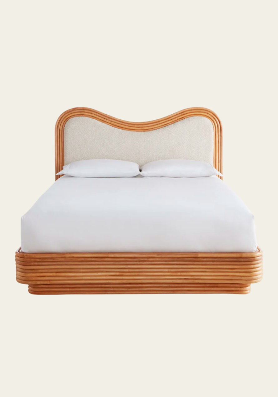 Rattan platform bed with upholstered headboard.
