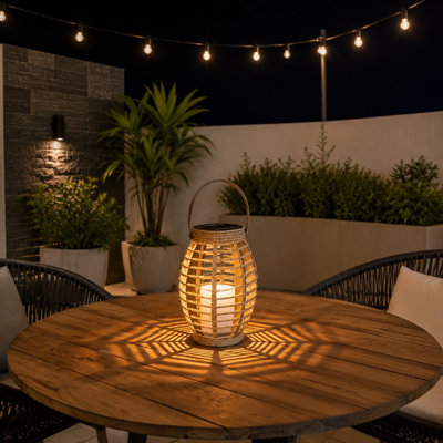 An 8.3 Inch solar-powered rattan lantern with Handle and Rope Weave Design uses a Warm White LED with Auto Dusk-to-Dawn operation; No Wires Needed, and it can be hung or placed on a tabletop outdoors.