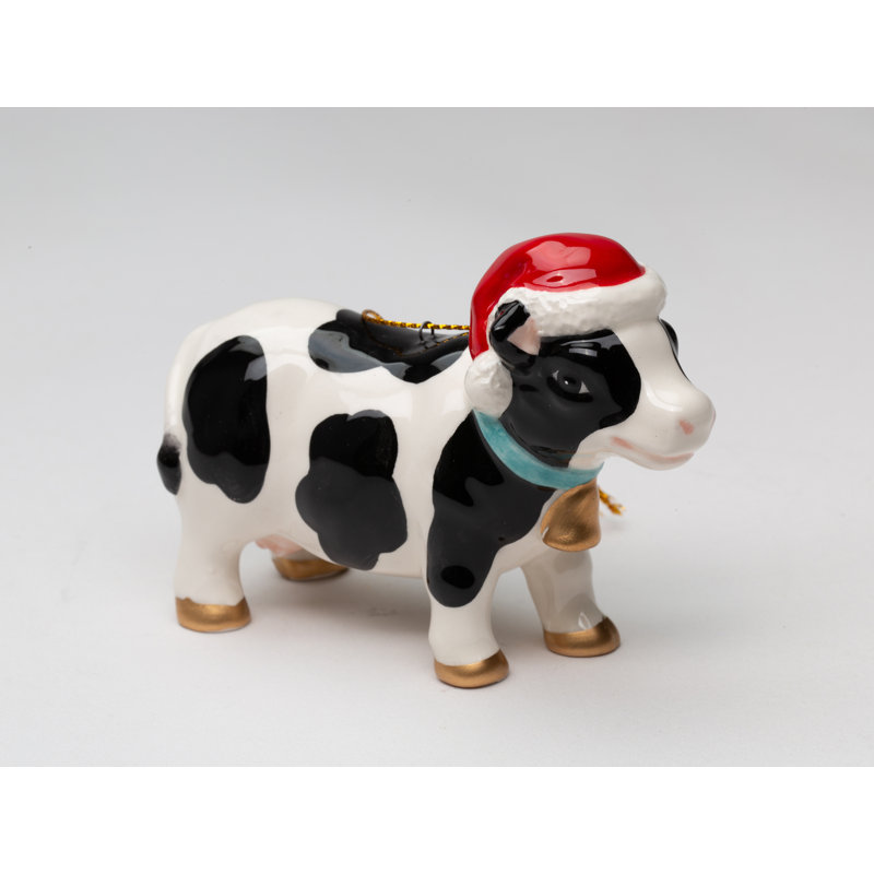 Vache portant un ornement de Noël suspendu à un chapeau de Noël