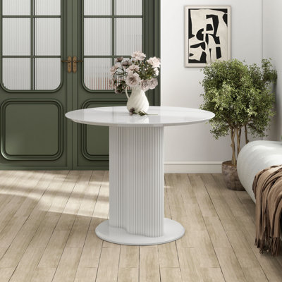 Table de salle à manger ronde Hudgens avec plateau brillant et base cannelée