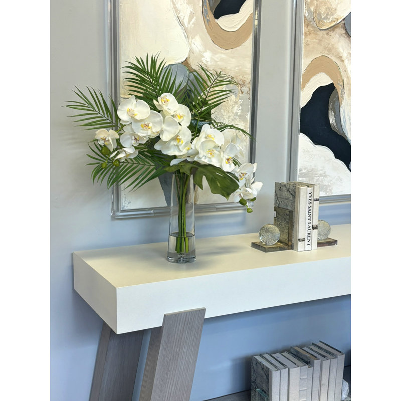 Arrangement floral tropical avec orchidées et feuilles de palmier
