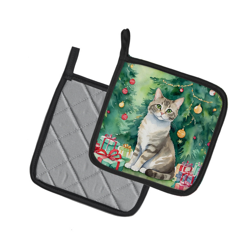 Pudelkatze chat près de l'arbre de Noël paire de poignées