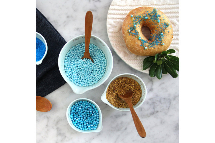 Countertop with sprinkles and decorated donut.