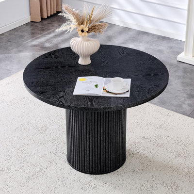 Une table de salle à manger circulaire épissée moderne d'un diamètre de 42 pouces, présentant des textures de couleur de bois noir en forme d'éventail en diagonale, interprétant l'esthétique et la fonctionnalité de la maison.