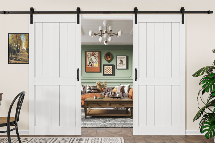 living room with white double barn sliding doors opening to cozy space with green accent wall, gallery art, and rust-colored sofa