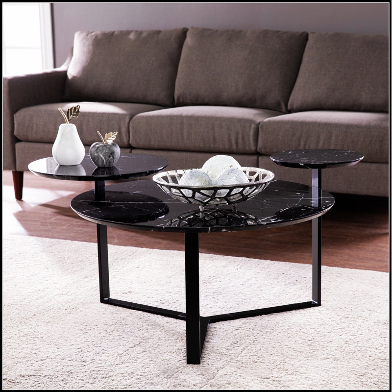 Table basse Saxelby en faux marbre avec un design élégant et beaucoup de rangement, parfaite pour les salons modernes et les espaces de divertissement.