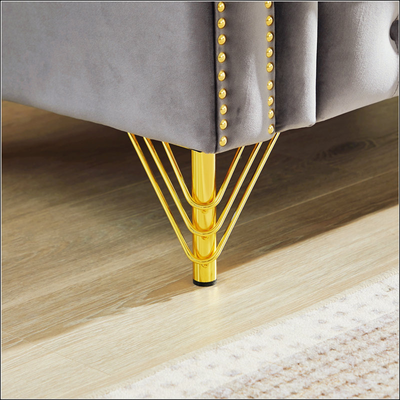 Luxueux canapé Chesterfield en velours avec coussins ronds, clous en cuivre, boutons touffetés et pieds en métal pour des espaces de vie élégants