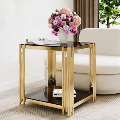 Table basse moderne en verre transparent avec structure asymétrique en métal, finition dorée et tablette inférieure pour un rangement élégant