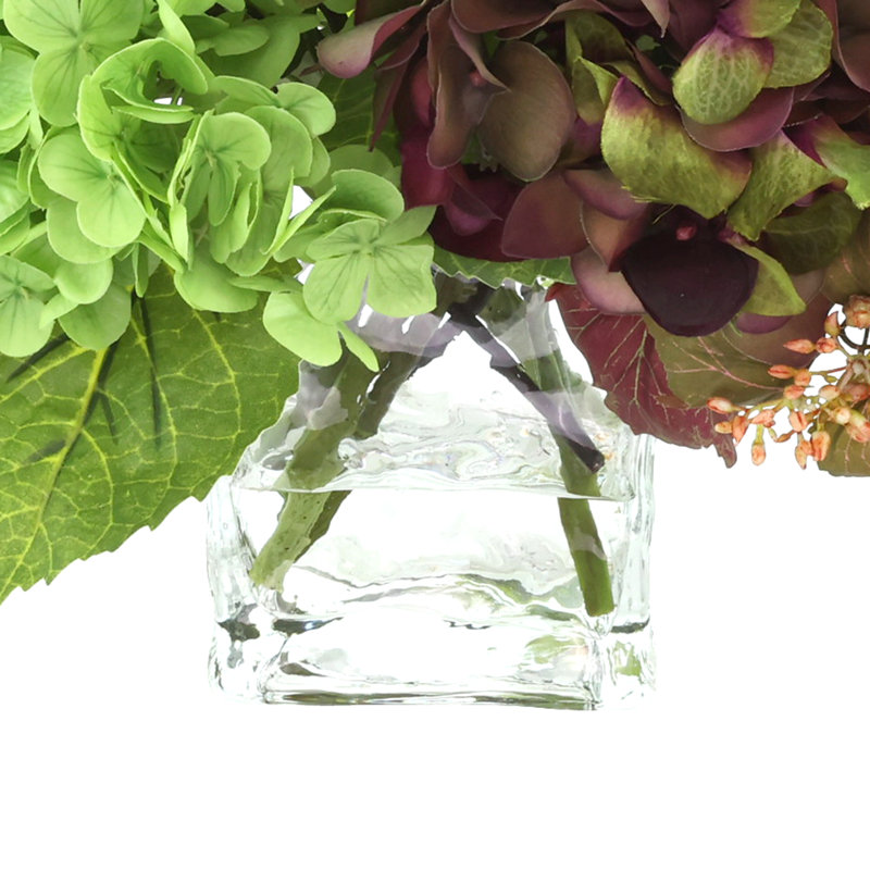 Hortensia et renoncule dans un vase en verre