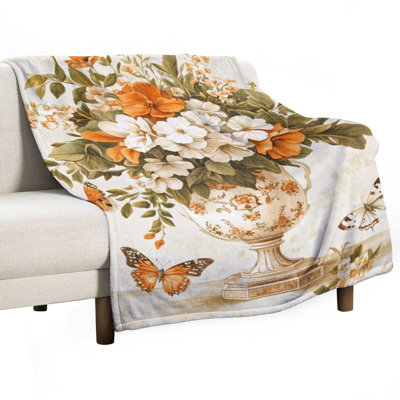 Papillons flottant près d'un vase orné rempli de jeté en flanelle de luxe, couverture douce et chaude pour le canapé-lit du salon