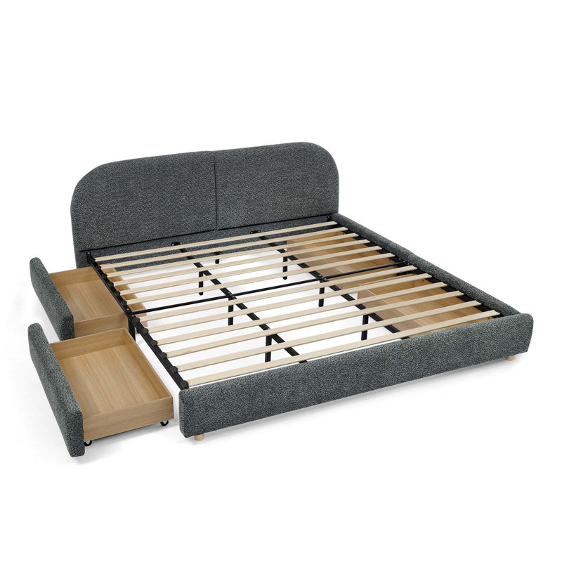 Structure de lit rembourrée avec tête de lit courbée et quatre tiroirs de rangement à roulettes pour matelas très grand.