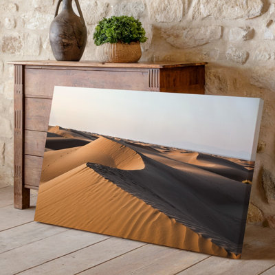 Toile, "Un vaste paysage désertique pendant l'heure dorée", mettant en vedette des dunes de sable ondulées avec des courbes fluides et une toile complexe