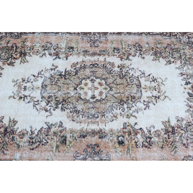 Tapis turc classique classique avec un élégant motif floral dans des tons de terre discrets pour un style de décoration traditionnelle
