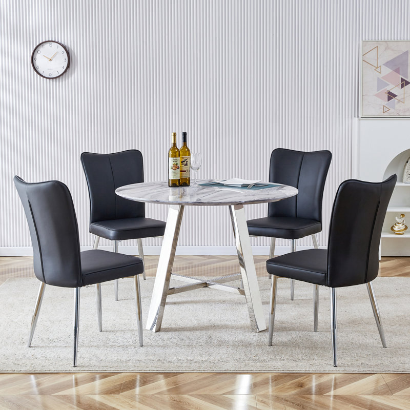 Ensemble de table et de chaises. Ensemble de table de salle à manger moderne en bois aggloméré de 42 po de diamètre - 4 chaises en polyuréthane avec un motif à rayures verticales sur le dossier. Bureau imitation marbre avec pieds en acier inoxydable.