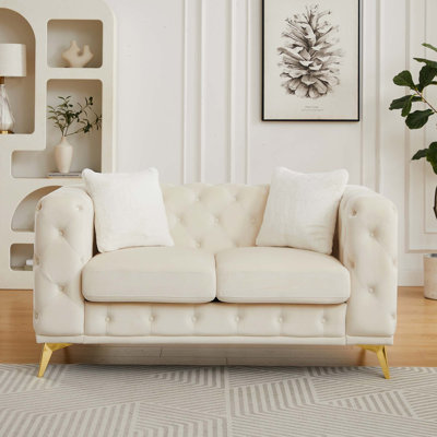 Canapé Chesterfield classique en velours avec détails capitonnés et coussins décoratifs