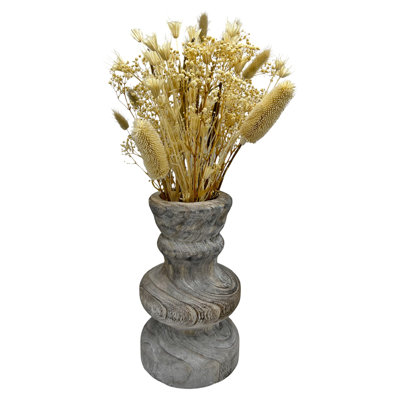 Arrangement de fleurs mélangées préservées dans un vase en bois
