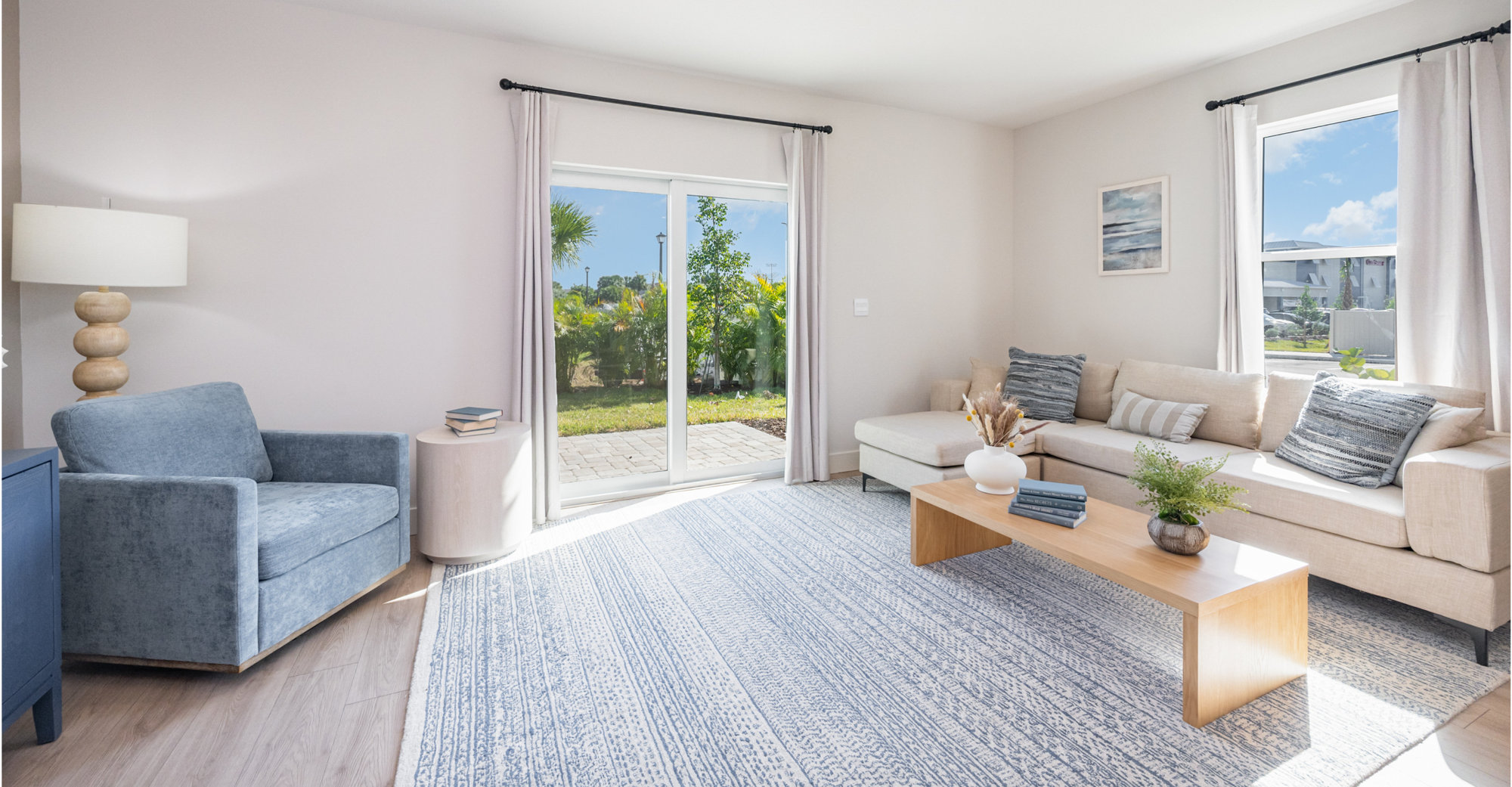 Living room interior with blue accent chair, couch, and area rug.