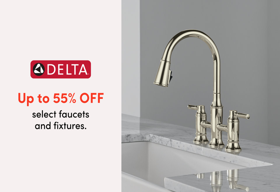 Brushed gold pull-down kitchen faucet dispensing water over a white quartz countertop in a modern kitchen.